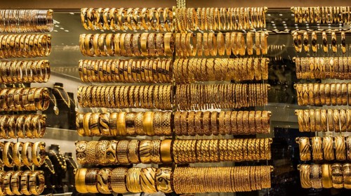 Shop display of dozens of golden bracelets and bangles