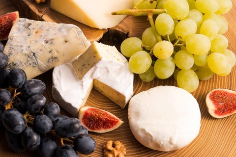 Assortment of cheese with fruits and grapes