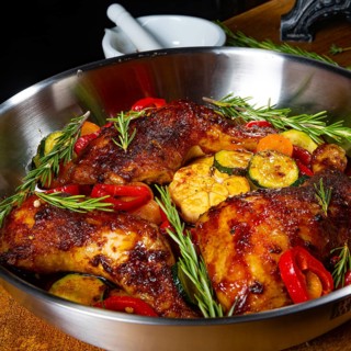 Roasted chicken legs with various vegetables and spices