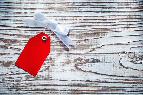 Red shopping tag on vintage wooden board