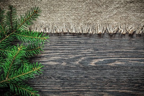 Vintage burlap pine branch on wooden board Christmas background