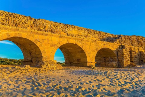 Stunning sunset on the Mediterranean coast in Israel. Well-preserved aqueduct, built in Caesarea at