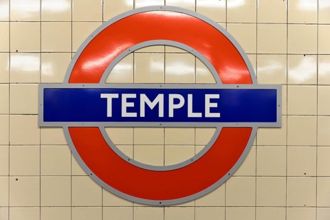 The red and blue Tube logo of Temple Station on a tiled background, London, London region, England,