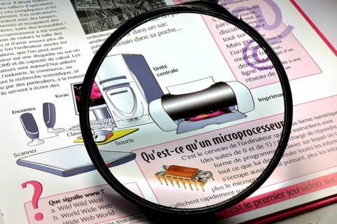 Magnifying glass on a book of explanations on the invention of the computer