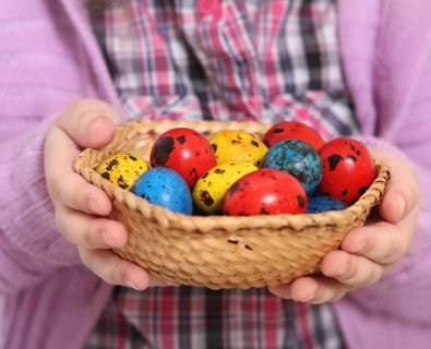 Cute little girl holding basket with easter eggs. Close up