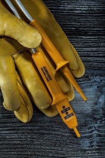 Set of electric tester safety gloves on vintage wooden board
