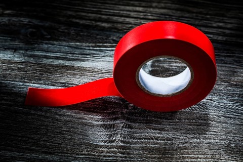 Rolled insulating tape on vintage wooden board