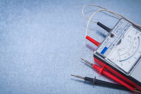 Electrician's instrument of measurement on scratched metallic background construction concept