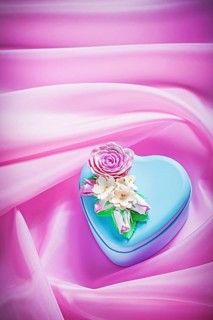Blue gift box with present on pink fabric background holidays concept