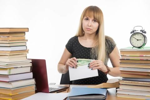 Upset girl student puts money in an envelope to bribe the teacher in the exam