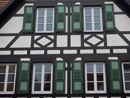 Detailed view of a half-timbered house with green shutters and windows, kandel, pfalz, germany