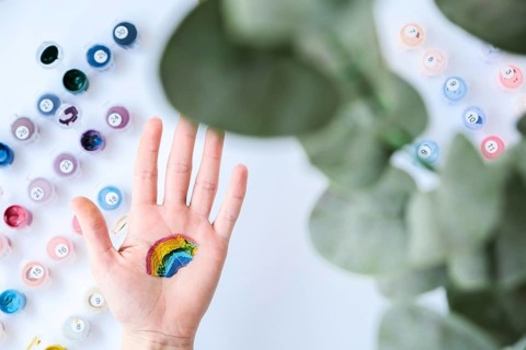 Rainbow LGBTQ flag painted on hand. Support for lgbt community. Honour of pride month. Connecting