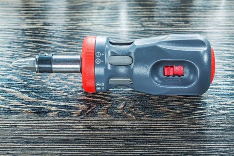 Screwdriver on wooden board top view