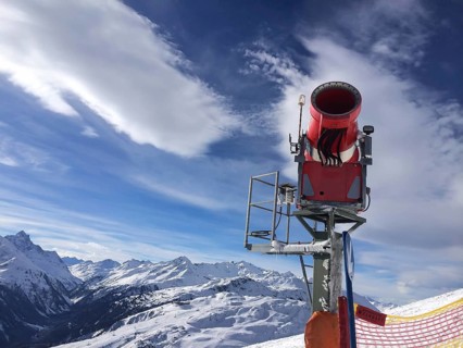 Modern red snow cannon near the ski piste in the high mountains