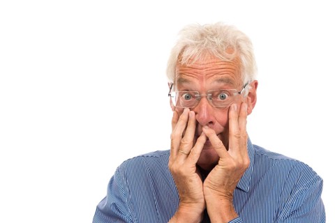 Portrait surprised senior man isolated against white background