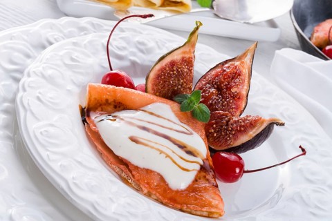 Flambiertes pfannkuchen mit feigen und kirschen