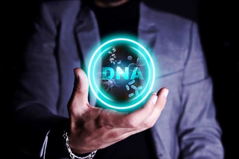 A person holding a holographic display of DNA strands and molecular structures.