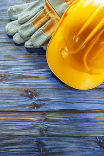 Protective gloves hard hat on vintage wooden board