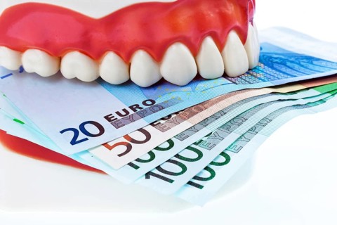 A dental model at the dentist with euro banknotes, costs for health studio admission, Federal