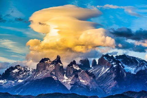 Magnificent cumulus clouds in the rays of the sunset. Torres del Paine National Park. Summer in the