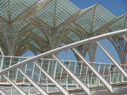 Architectural details of a modern structure with glass roof and steel construction against blue