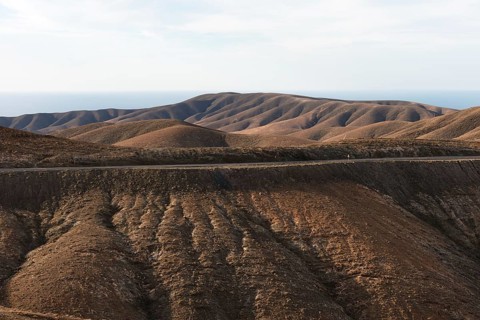 Gentle brown hills under a blue sky in an arid landscape. Viewpoint Mirador Astronomico de