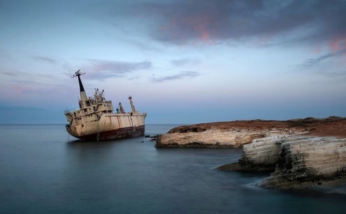 Abandoned Ship on the rocky coast with beautiful blue and orange morning colors creating an exotic