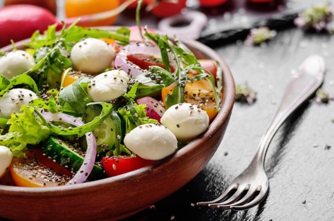Vegetable salad with mocarella cheese, lettuce, cherry tomatoes, radish, cucumber, onion and basil