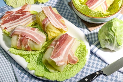Preparation of savoy cabbage roulades with bacon on cabbage leaves