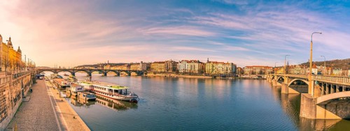Colorful panorama with the Vltava river, its bridges and the buildings of Prague city, on a sunny