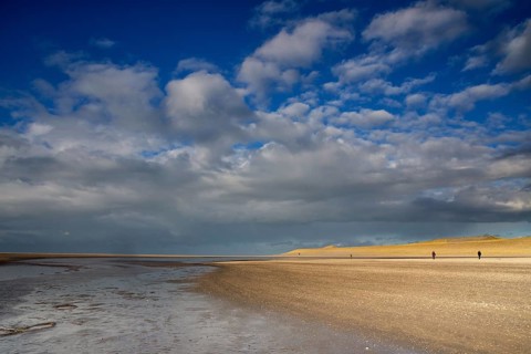 Two people making a beachwalk on the Maasvlaktestrand. This beach is a result of the creation of