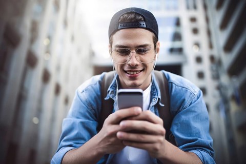 Man Sitting Listening Music Earphones Concept. Cheerful young guy listening the music