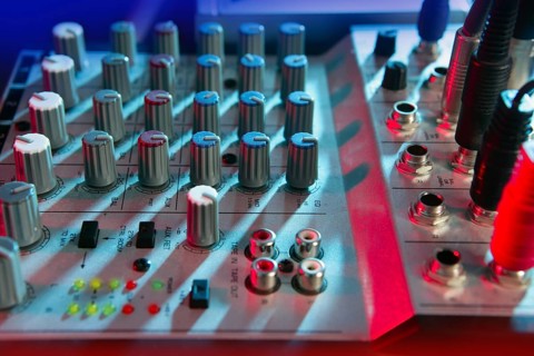 Audio mixer music desk under colorful lights equipment