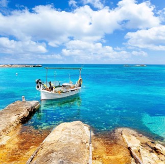Els Pujols beach in Formentera with traditional fishing boat in summer day