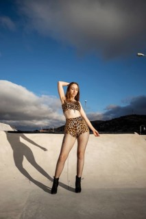 Vertical portrait of a young Caucasian woman with armpit hair dancing urban dance in the street in