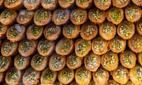 Turkish traditional dessert Kadayif baked in syrup served with nut powder