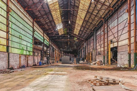 Large abandoned factory building with open roof and metal supports, The Galvanising Shop, Lost