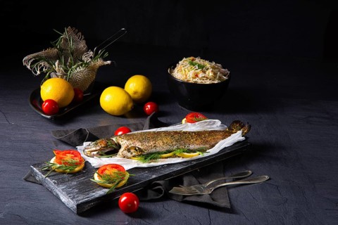 Baked trout with herb filling and tomatoes