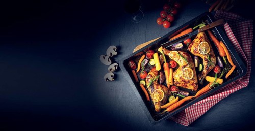 Grilled chicken legs with various vegetables and herbs