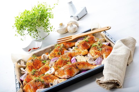 Prepared chicken legs with various vegetables and herbs