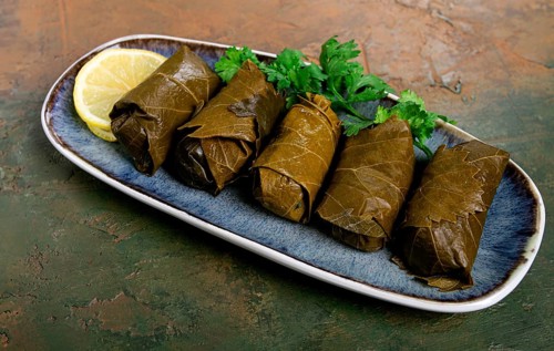 Dolma, minced meat with rice, in grape leaves, rolls with minced meat, on a plate, top view, no