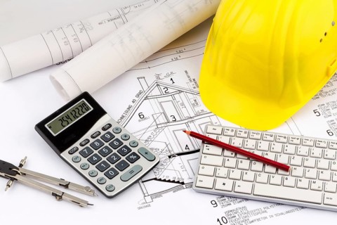 An architect's construction plan with a builder's helmet. Symbolic photo for financing and planning