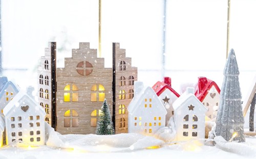 Cozy Christmas decor tiny house of small size on window sill with snow outside the window. Gift for