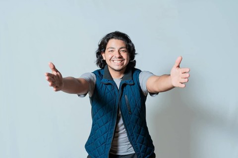 Happy young man welcoming with open arms isolated. Hospitable person opening arms to the camera