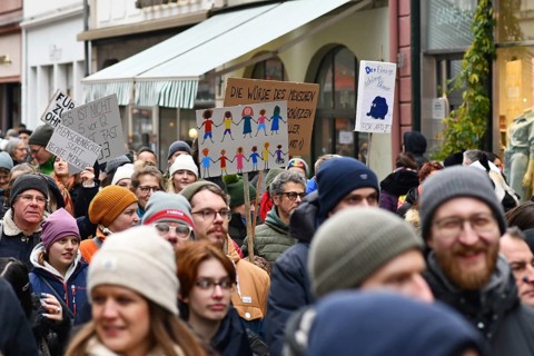 Heidelberg, Germany - February 12th 2025: Person holding up sign showing drawing of people of color