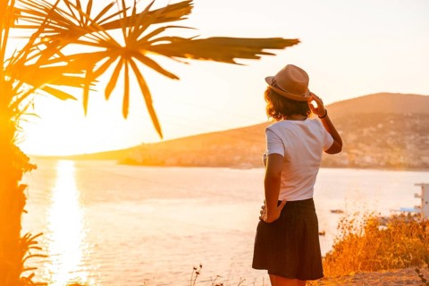 Panoramic view of the city and a tourist woman at sunset of Sarande or Saranda on the Albanian