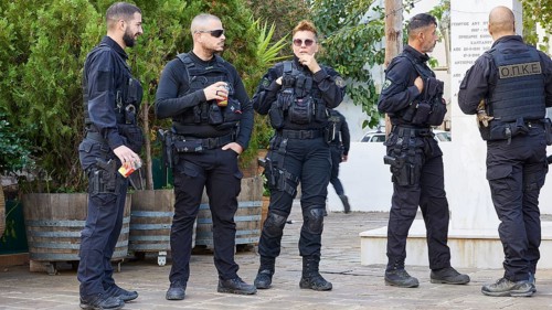 Group of uniformed Greek police officers in riot gear relaxing outdoors, visit of German President