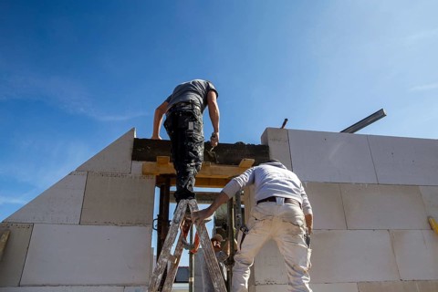 Bricklayers work on a new detached house