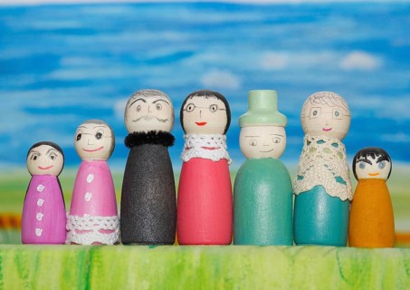 Seven funny painted wooden cones man and woman, big and small in front of a colourful painted