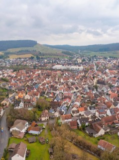 Aerial view of a town with red tiled roofs and surrounding hills on a cloudy day, Großbottwar,